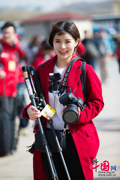 2016年兩會(huì)，人民大會(huì)大堂前，一位笑容燦爛的紅衣女記者正步入大會(huì)堂。中國(guó)網(wǎng) 鄭亮 攝