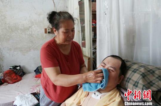 每次喂完食物后，梁青蘭都要仔細地幫兒子清理干凈?！∩忻鱾b 攝