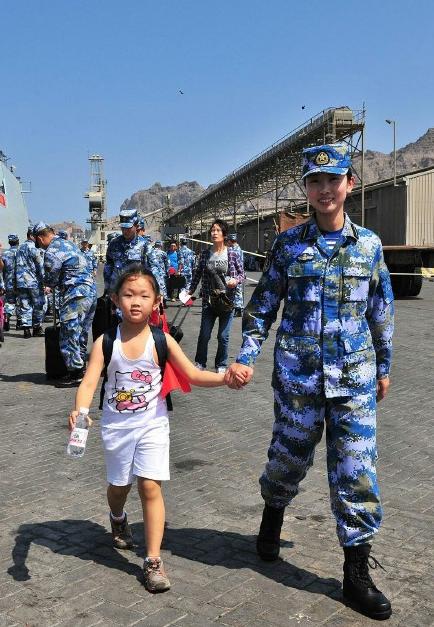2015年3月，也門，海軍女戰士牽著一名小女孩的手準備登上軍艦。