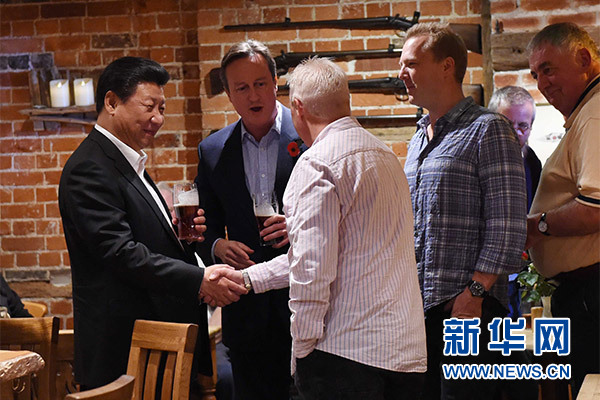 這是習近平與卡梅倫飲啤酒，并同當?shù)孛癖娊徽劇Ｐ氯A社記者 饒愛民 攝